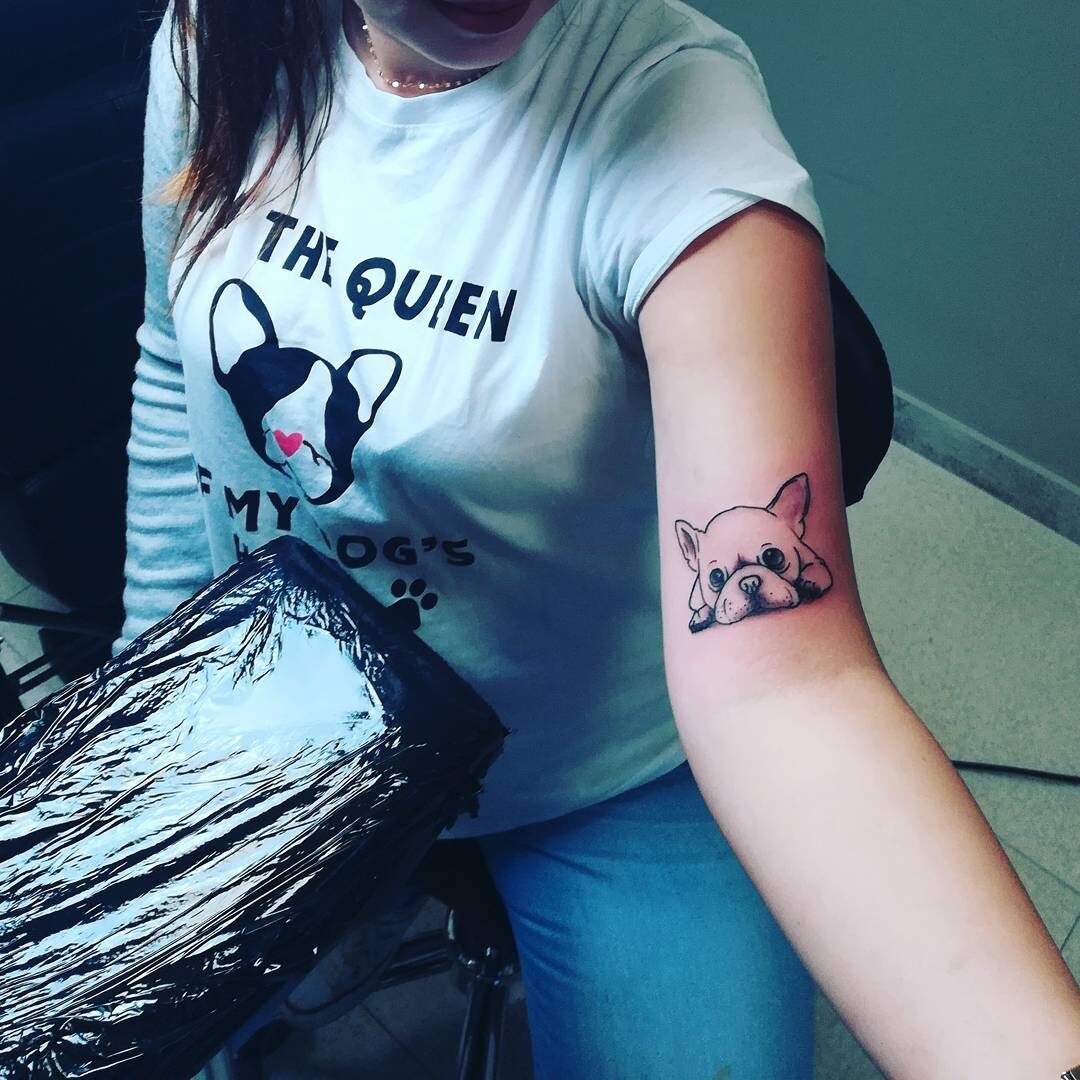 Tatuaż na ręce kobiety przedstawiający psa